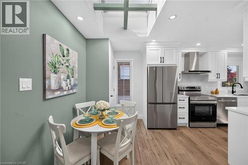 Modern kitchen featuring white cabinetry, stainless steel appliances, wood-finish flooring, and a skylight - 101 Loyalist Drive, Hamilton, ON - Indoor Photo Showing Other Room