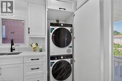 Integrated laundry center featuring a stacked washer and dryer within custom cabinetry - 
