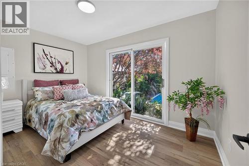 Bright interior space with wood-finish flooring, light-toned walls, and a contemporary flush-mount ceiling light - 101 Loyalist Drive, Hamilton, ON - Indoor Photo Showing Bedroom