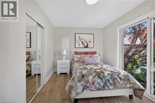 Bedroom featuring wood-finish flooring, a mirrored sliding closet, and a large sliding glass door - 101 Loyalist Drive, Hamilton, ON - Indoor Photo Showing Bedroom