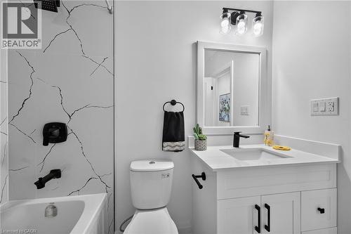 Bathroom featuring a white vanity with an integrated sink, matte black faucet, and a framed mirror - 101 Loyalist Drive, Hamilton, ON - Indoor Photo Showing Bathroom