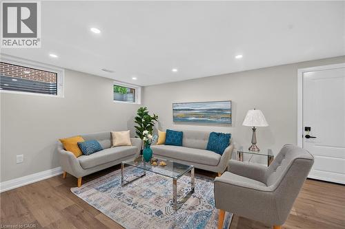 Spacious living area featuring recessed lighting, light gray walls, wood-finish flooring, and white trim - 101 Loyalist Drive, Hamilton, ON - Indoor