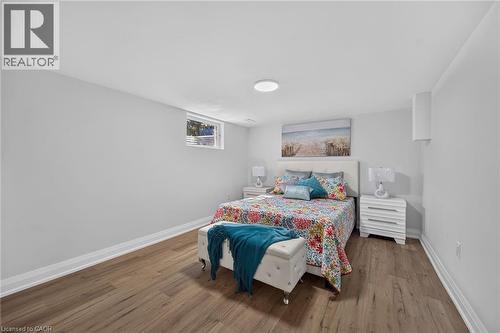 Spacious room featuring wood-finish flooring, light grey walls, white baseboards, and a small casement window - 101 Loyalist Drive, Hamilton, ON - Indoor Photo Showing Bedroom