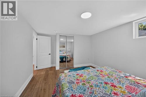 Neutral wall paint and wood-finish flooring define this interior space - 101 Loyalist Drive, Hamilton, ON - Indoor Photo Showing Bedroom