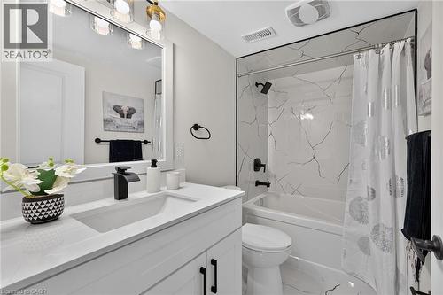 Modern bathroom featuring a white vanity with integrated sink, black matte faucet, and matching hardware - 101 Loyalist Drive, Hamilton, ON - Indoor Photo Showing Bathroom