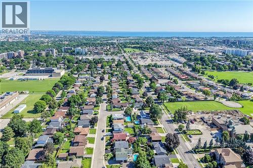 Expansive aerial perspective showcasing a residential area with varied housing styles, numerous mature trees, and several green spaces - 101 Loyalist Drive, Hamilton, ON - Outdoor With View