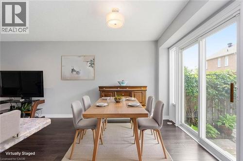 Dining area featuring dark wood-finish flooring, light grey wall paint, and a sliding glass door - 2248 Seton Crescent, Burlington, ON - Indoor Photo Showing Dining Room