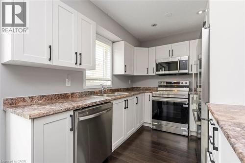Kitchen with white shaker-style cabinetry, stainless steel appliances, and dark wood-finish flooring - 2248 Seton Crescent, Burlington, ON - Indoor Photo Showing Kitchen With Stainless Steel Kitchen With Double Sink
