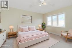 Bedroom featuring light-toned walls, white trim, and neutral carpeting - 