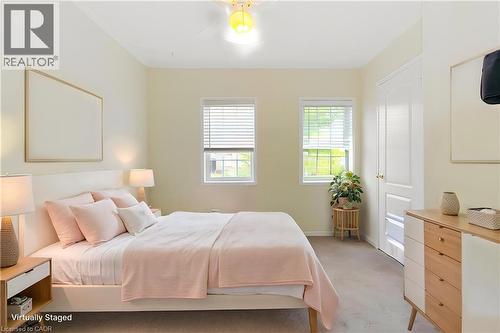 Bedroom featuring two windows with blinds, a ceiling light fixture, a paneled door, and neutral-toned wall paint - 2248 Seton Crescent, Burlington, ON - Indoor Photo Showing Bedroom