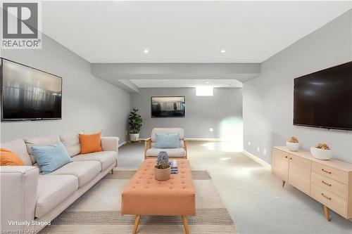 Spacious lower-level room featuring light gray walls, recessed lighting, and carpeted flooring - 2248 Seton Crescent, Burlington, ON - Indoor Photo Showing Living Room