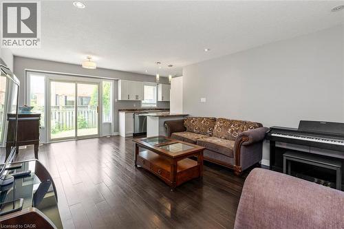 Spacious living area featuring dark wood-finish flooring, recessed lighting, and direct access to the outdoor space via sliding glass doors - 2248 Seton Crescent, Burlington, ON - Indoor Photo Showing Living Room