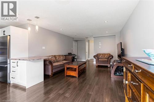 Open-concept living area featuring dark wood-finish flooring, recessed ceiling lights, and light gray wall paint - 2248 Seton Crescent, Burlington, ON - Indoor
