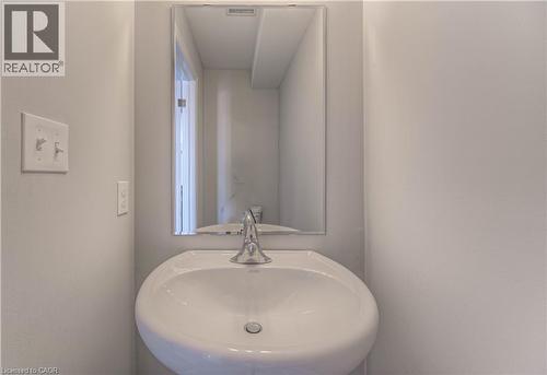 Pedestal sink with a chrome faucet set against light gray walls - 44 Harrison Drive, Cambridge, ON - Indoor Photo Showing Bathroom