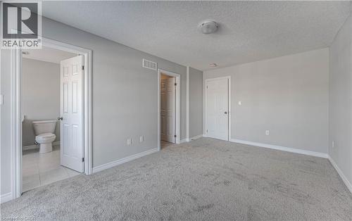 Spacious room featuring light grey carpeting, white baseboards, and a neutral wall color - 44 Harrison Drive, Cambridge, ON - Indoor Photo Showing Other Room