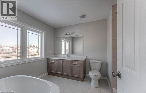 Bathroom featuring a double vanity with stone-finish countertop, undermount sink, and wood-finish cabinetry - 44 Harrison Drive, Cambridge, ON - Indoor Photo Showing Bathroom