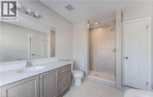 Bright bathroom featuring a single vanity with stone-finish countertop, undermount sink, and chrome faucet - 44 Harrison Drive, Cambridge, ON - Indoor Photo Showing Bathroom