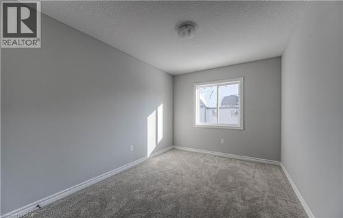 Neutral gray walls with white baseboards frame a window with white trim - 44 Harrison Drive, Cambridge, ON - Indoor Photo Showing Other Room