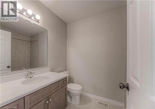 Bathroom featuring a wood-finish vanity with a light-colored countertop and integrated sink - 44 Harrison Drive, Cambridge, ON - Indoor Photo Showing Bathroom