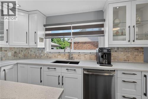 White shaker cabinetry with dark hardware, light speckled countertops, and a mosaic tile backsplash - 386 Upper Kenilworth Avenue, Hamilton, ON - Indoor Photo Showing Kitchen With Double Sink