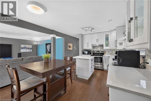 Open-concept kitchen featuring white cabinetry, stone countertops, a tiled backsplash, and stainless steel appliances - 386 Upper Kenilworth Avenue, Hamilton, ON - Indoor