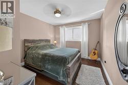 Room featuring wood-finish flooring, a contemporary ceiling fan, and painted walls - 