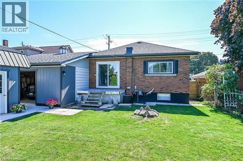 Expansive rear yard featuring a brick facade, sliding glass door, and a detached garage with a metal roof - 386 Upper Kenilworth Avenue, Hamilton, ON - Outdoor