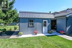 Detached shed featuring a metal roof, single window, and a white paneled door - 