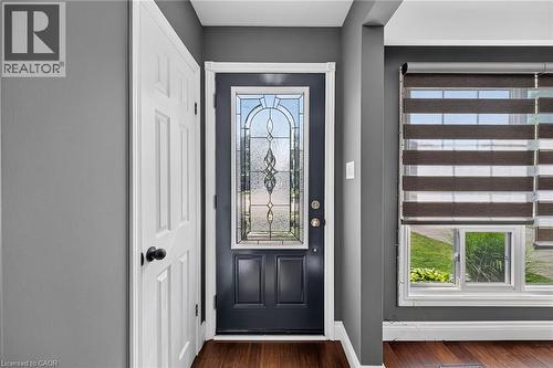 Entryway featuring a dark paneled door with decorative leaded glass, white trim, and wood-finish flooring - 386 Upper Kenilworth Avenue, Hamilton, ON - Indoor Photo Showing Other Room