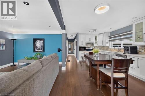 Open-concept living space featuring wood-finish flooring, recessed lighting, white perimeter cabinetry, a mosaic tile backsplash, and an undermount sink - 386 Upper Kenilworth Avenue, Hamilton, ON - Indoor
