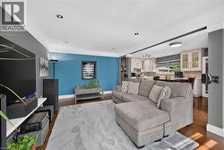 Open concept living area featuring wood-finish flooring, recessed lighting, and crown molding - 