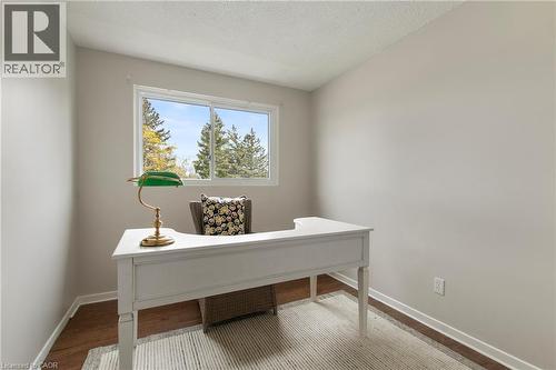 Room featuring neutral wall tones, wood-finish flooring, white trim, and a window providing natural light - 29 Woodlawn Avenue, Brantford, ON - Indoor