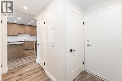 Entryway featuring wood-finish flooring, white doors with matte black hardware, and recessed lighting - 72 Erb Street E Unit# 103, Waterloo, ON - Indoor