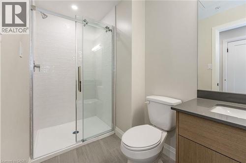Contemporary bathroom featuring a walk-in shower with subway tile surround, sliding glass door, and integrated shower bench - 72 Erb Street E Unit# 103, Waterloo, ON - Indoor Photo Showing Bathroom