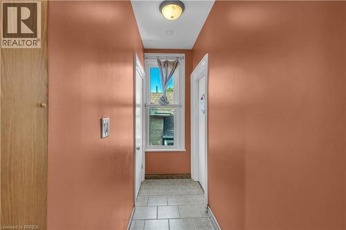 Hallway featuring terra cotta walls, light-colored ceiling, flush-mount lighting, and tiled flooring - 17 Scarfe Avenue, Brantford, ON - Indoor Photo Showing Other Room