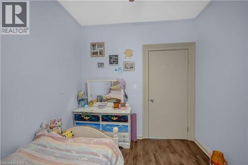 Light blue walls with crown molding and wood-finish flooring - 17 Scarfe Avenue, Brantford, ON - Indoor Photo Showing Bedroom