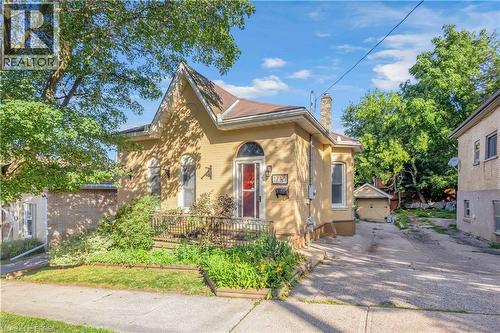 Brick exterior with arched windows, a covered front porch, and an asphalt driveway - 17 Scarfe Avenue, Brantford, ON - Outdoor