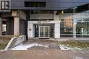 Modern building entrance featuring glass double doors, a white panel facade, dark brickwork, and concrete columns - 158 King Street N Unit# 81201, Waterloo, ON  - Outdoor 