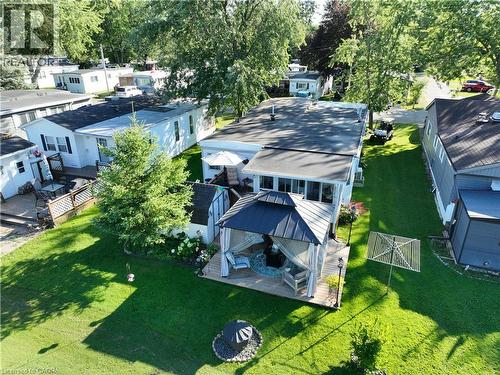 Expansive green lawn surrounds this property featuring an enclosed sunroom, a covered gazebo with privacy curtains, and a dedicated patio area - 580 Beaver Creek Road Unit# 189, Waterloo, ON - Outdoor