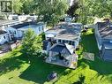 Expansive green lawn surrounds this property featuring an enclosed sunroom, a covered gazebo with privacy curtains, and a dedicated patio area - 580 Beaver Creek Road Unit# 189, Waterloo, ON  - Outdoor 