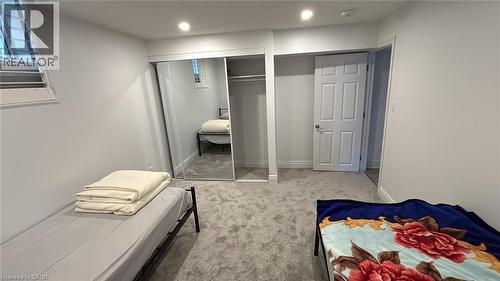 Carpeted room featuring a mirrored closet with sliding doors, a white paneled door, a single window with horizontal blinds, recessed lighting, and white baseboards - 252 Raymond Road Unit# Lower, Ancaster, ON - Indoor Photo Showing Other Room