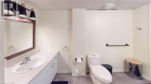 Bathroom featuring a single vanity with an oval basin, a dark wood-framed mirror, and a three-light fixture with black conical shades - 4101 Diana Park, Vineland, ON - Indoor Photo Showing Bathroom