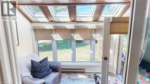Sunroom featuring multiple skylights, paneled walls, and tiled flooring - 4101 Diana Park, Vineland, ON - Indoor Photo Showing Other Room