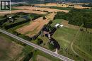 Expansive rural property featuring a main residence, cultivated fields, wooded areas, two white outbuildings, and a pond - 269 Brant County Road 22, Ancaster, ON 