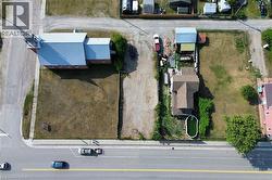 Rectangular lot featuring a detached residential structure, an adjacent structure with a metal roof, and a visible above-ground pool - 