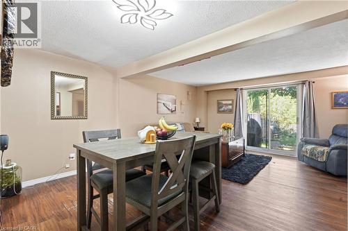 Open-concept living area featuring wood-finish flooring, a contemporary ceiling fixture, and neutral wall tones - 292 Mayview Court Unit# B, Waterloo, ON - Indoor