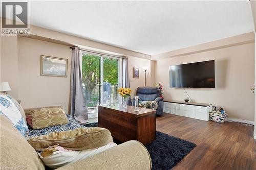 Living space featuring wood-finish flooring, light neutral wall tones, and recessed ceiling details - 292 Mayview Court Unit# B, Waterloo, ON - Indoor