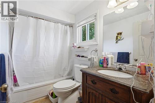 Bathroom featuring a full vanity with a stone-finish countertop, undermount sink, and dark wood-finish cabinetry - 292 Mayview Court Unit# B, Waterloo, ON - Indoor Photo Showing Bathroom