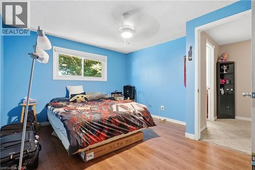 Bedroom featuring wood-finish flooring, a white trim window, and a ceiling fan with integrated lighting - 292 Mayview Court Unit# B, Waterloo, ON - Indoor Photo Showing Bedroom