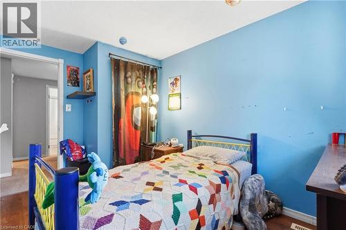 Bedroom featuring light blue walls, wood-finish flooring, a white ceiling, and a framed doorway - 292 Mayview Court Unit# B, Waterloo, ON - Indoor Photo Showing Bedroom